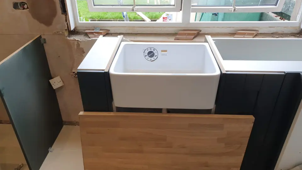 Belfast sink being fitted between new kitchen units by Dunedin Plumbing & Heating