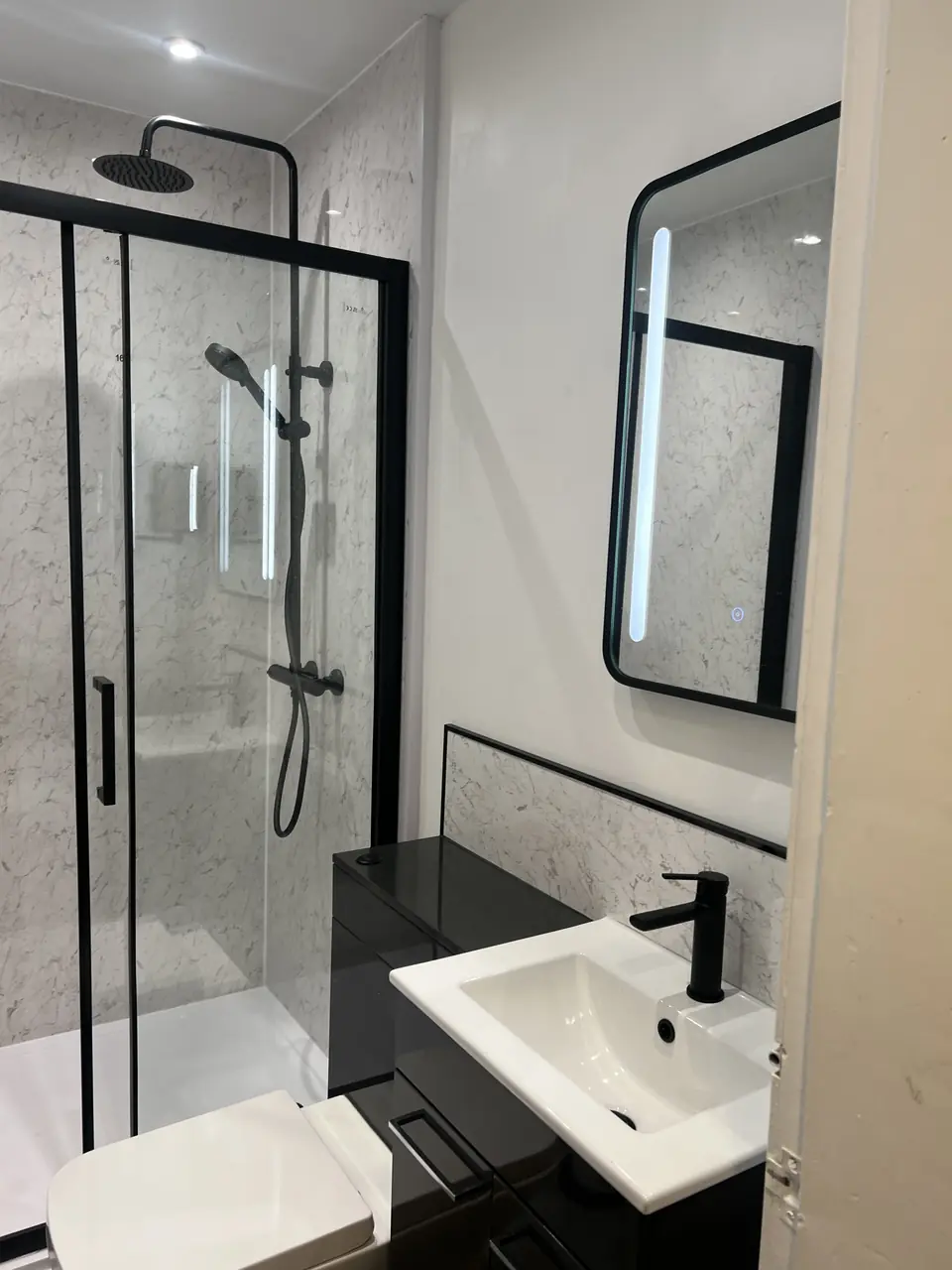 Black-framed shower enclosure and vanity in a Dunedin bathroom renovation
